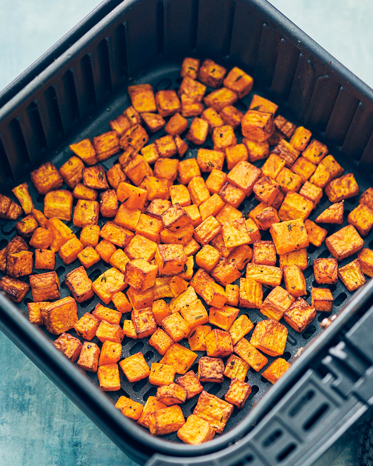 Roasted butternut squash in an air fryer basket after cooking.