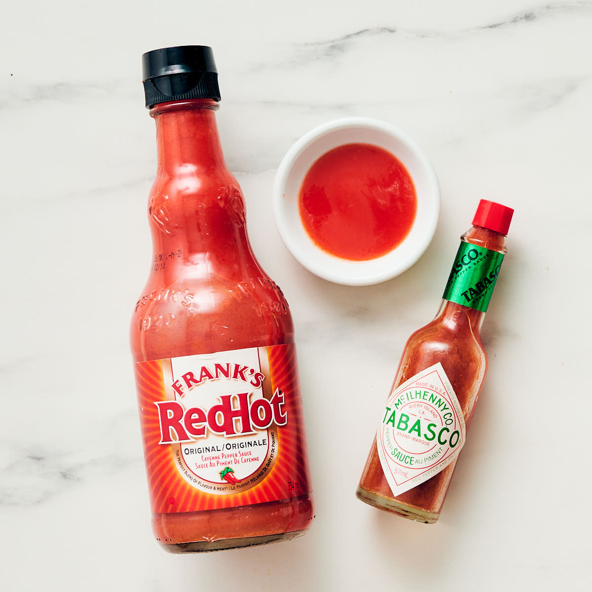 Louisiana-style hot sauce bottles (Frank's Red Hot and Tabasco) on a counter.