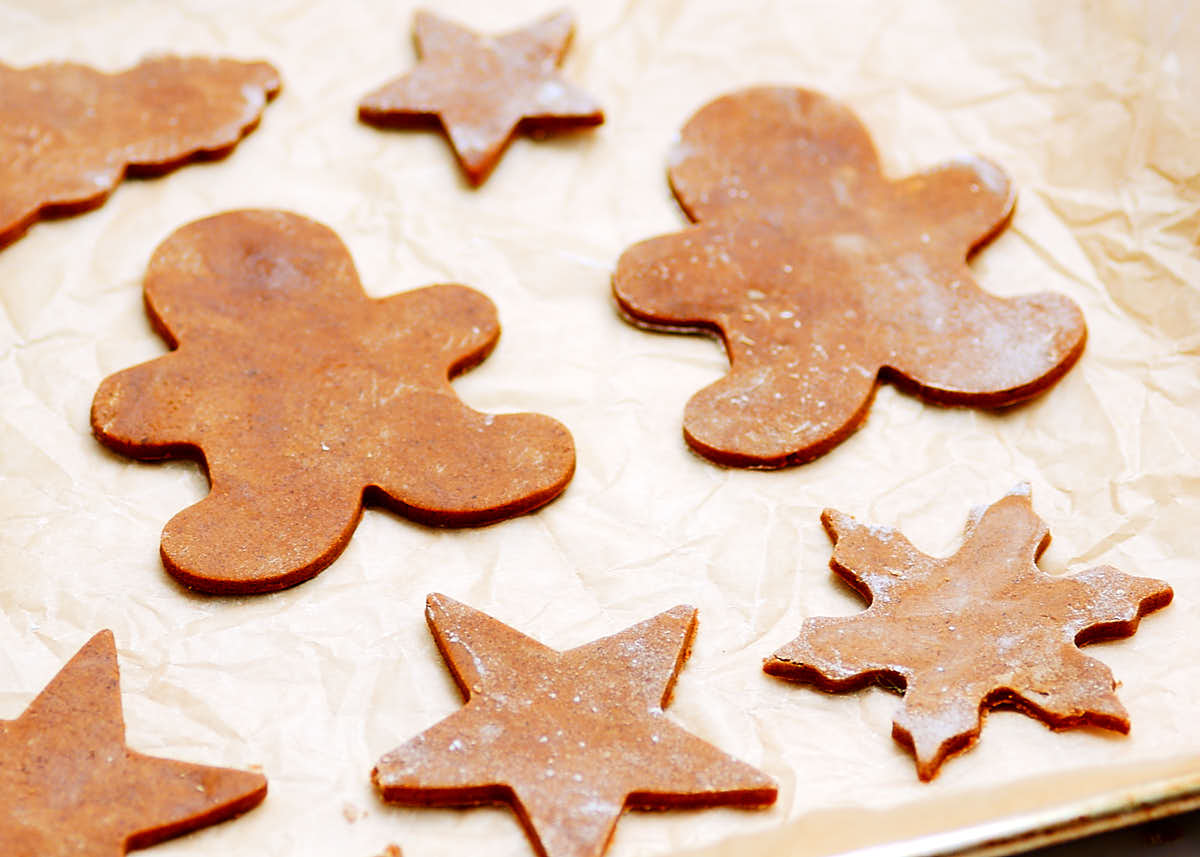 Gingerbread men cutouts on a baking sheet about to be baked.