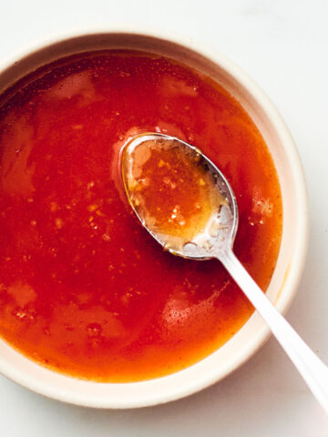 Easy honey sriracha sauce in a bowl with a spoon.