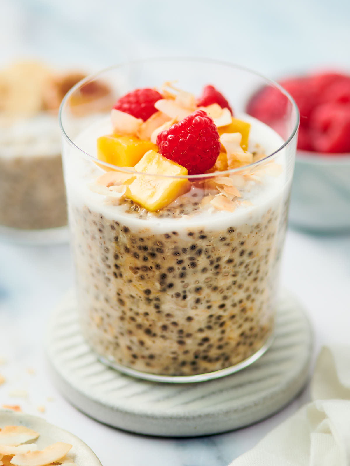 Overnight Oats with coconut milk in a glass jar topped with fruit.