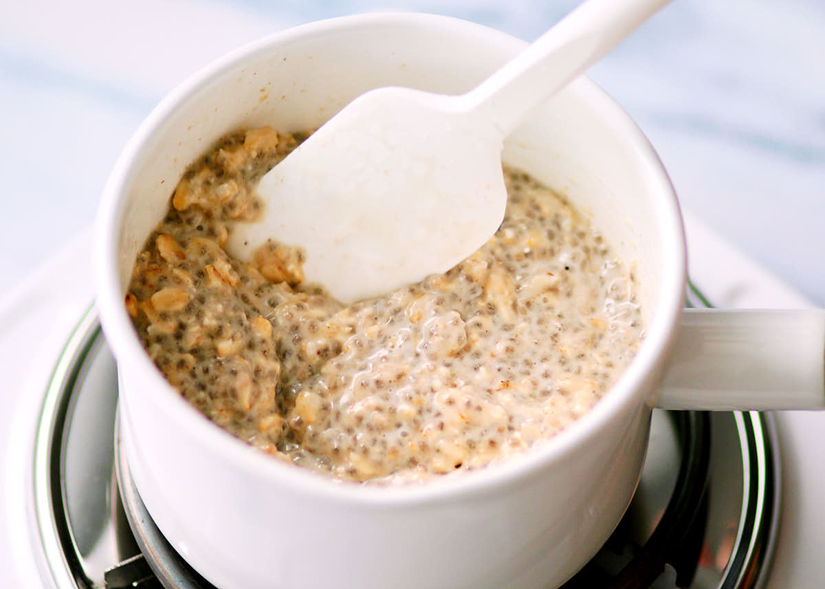 Warming up overnight oats with coconut milk in a saucepan.