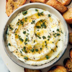 Whipped ricotta dip with honey, thyme, and pepper in a bowl.