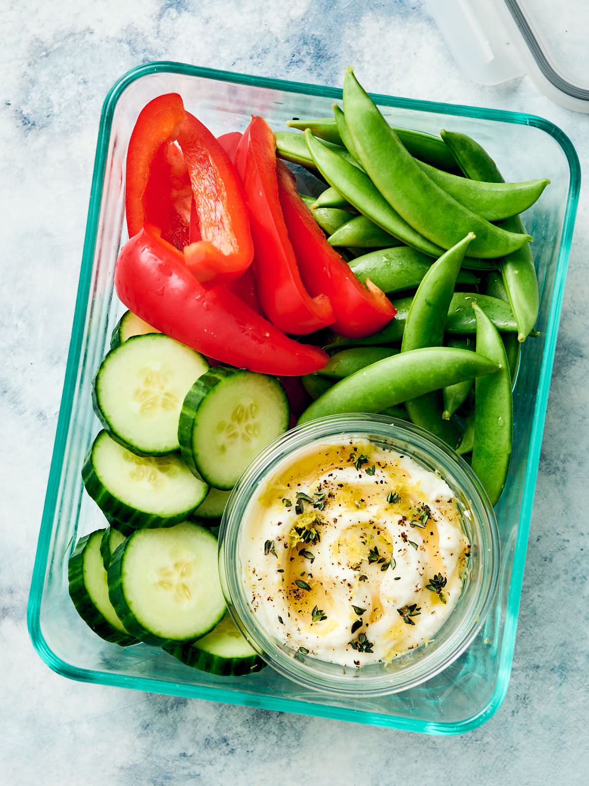 Whipped ricotta dip in a meal prep container with fresh veggies.
