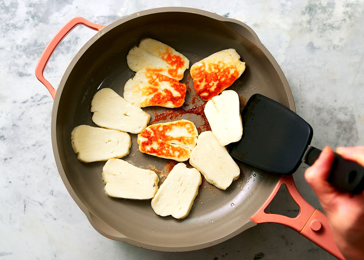 Searing Halloumi cheese in a non-stick skillet until golden brown.