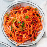 Easy Raw Carrot Salad on a blue dinner plate.