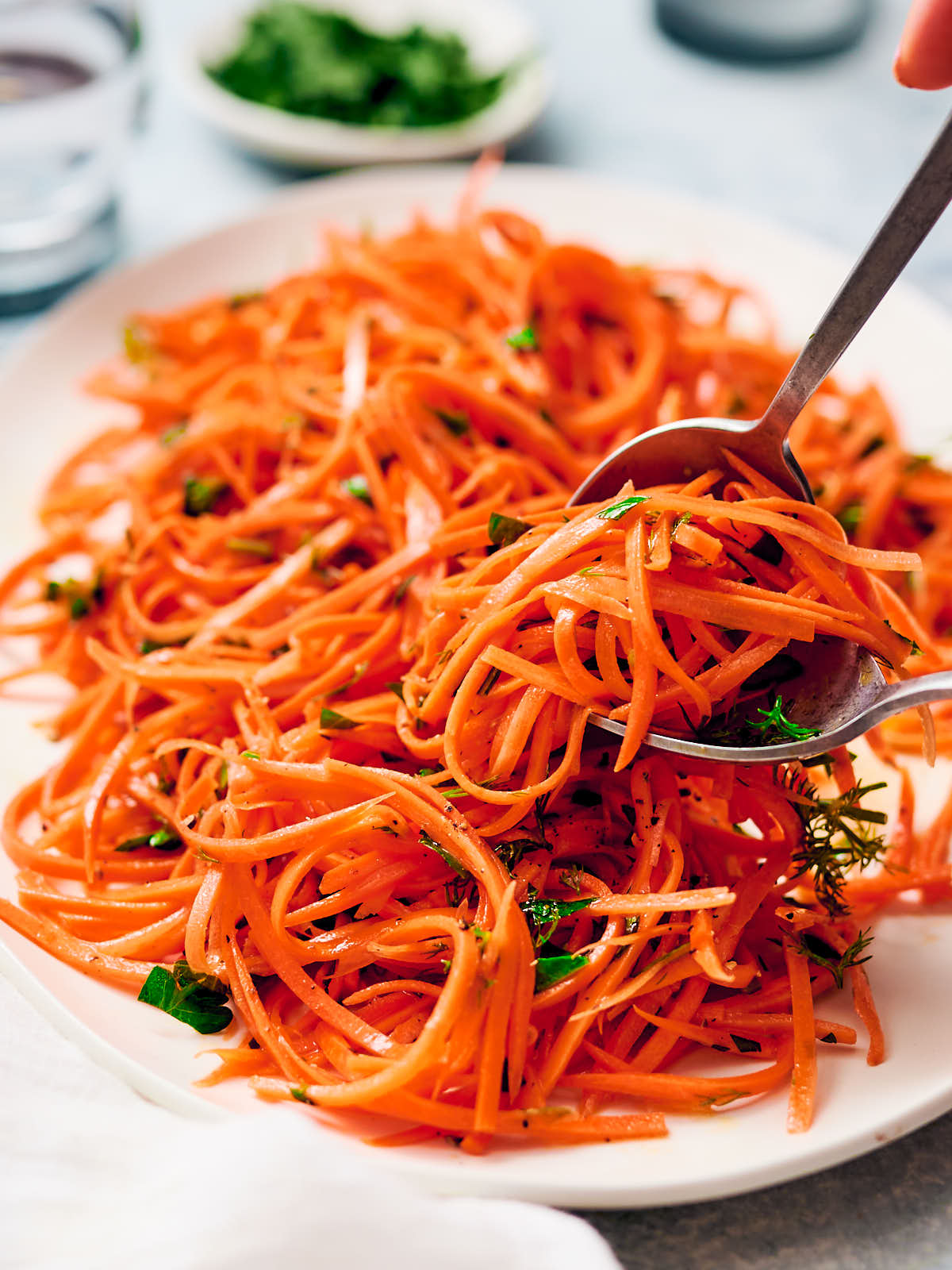 Raw carrot salad being served at the table.