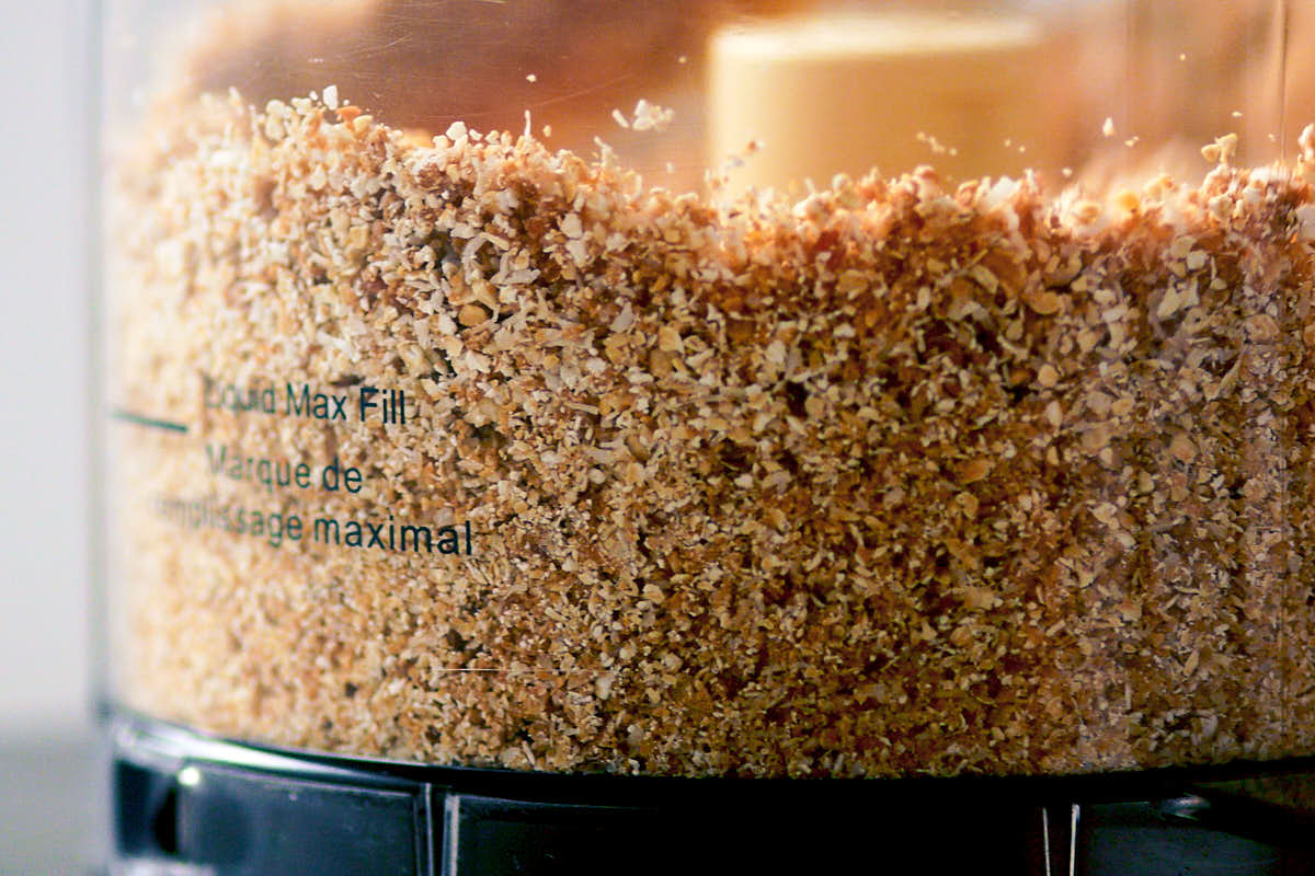 Pulsing peanut butter coconut ball mixture in a food processor.