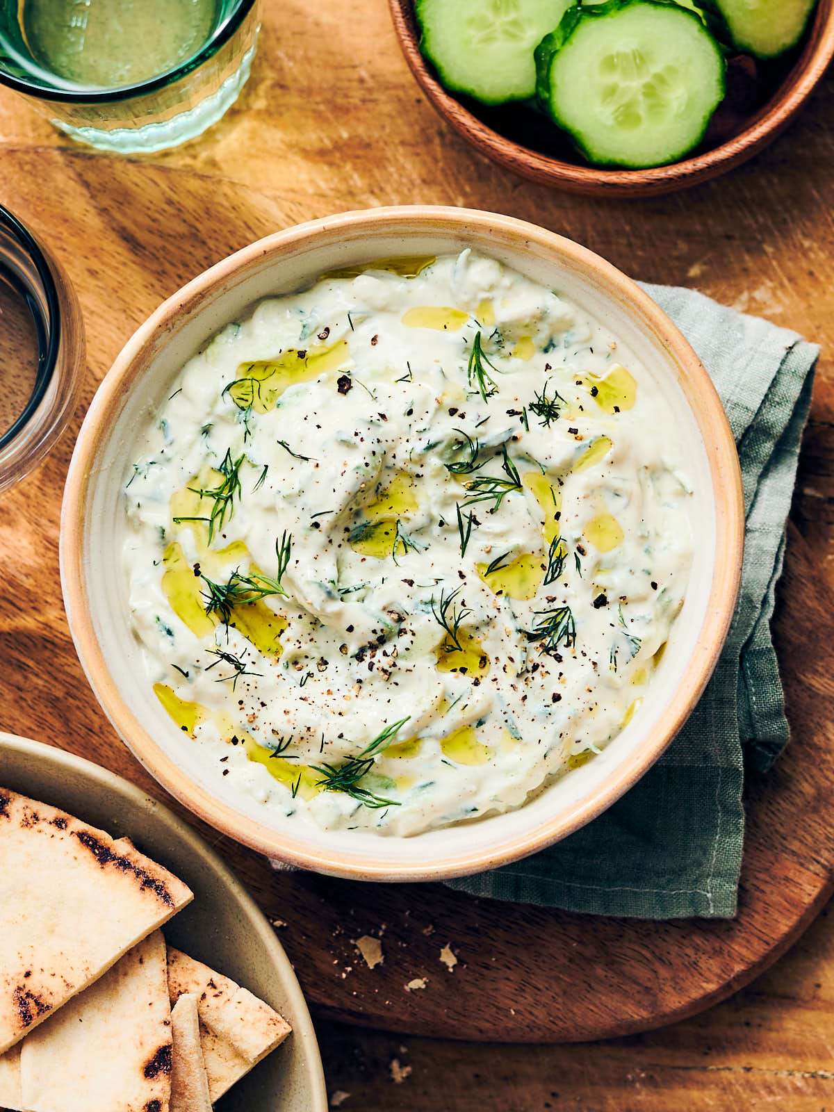 Best vegan tzatziki in a bowl served with pita and cucumber on the side.