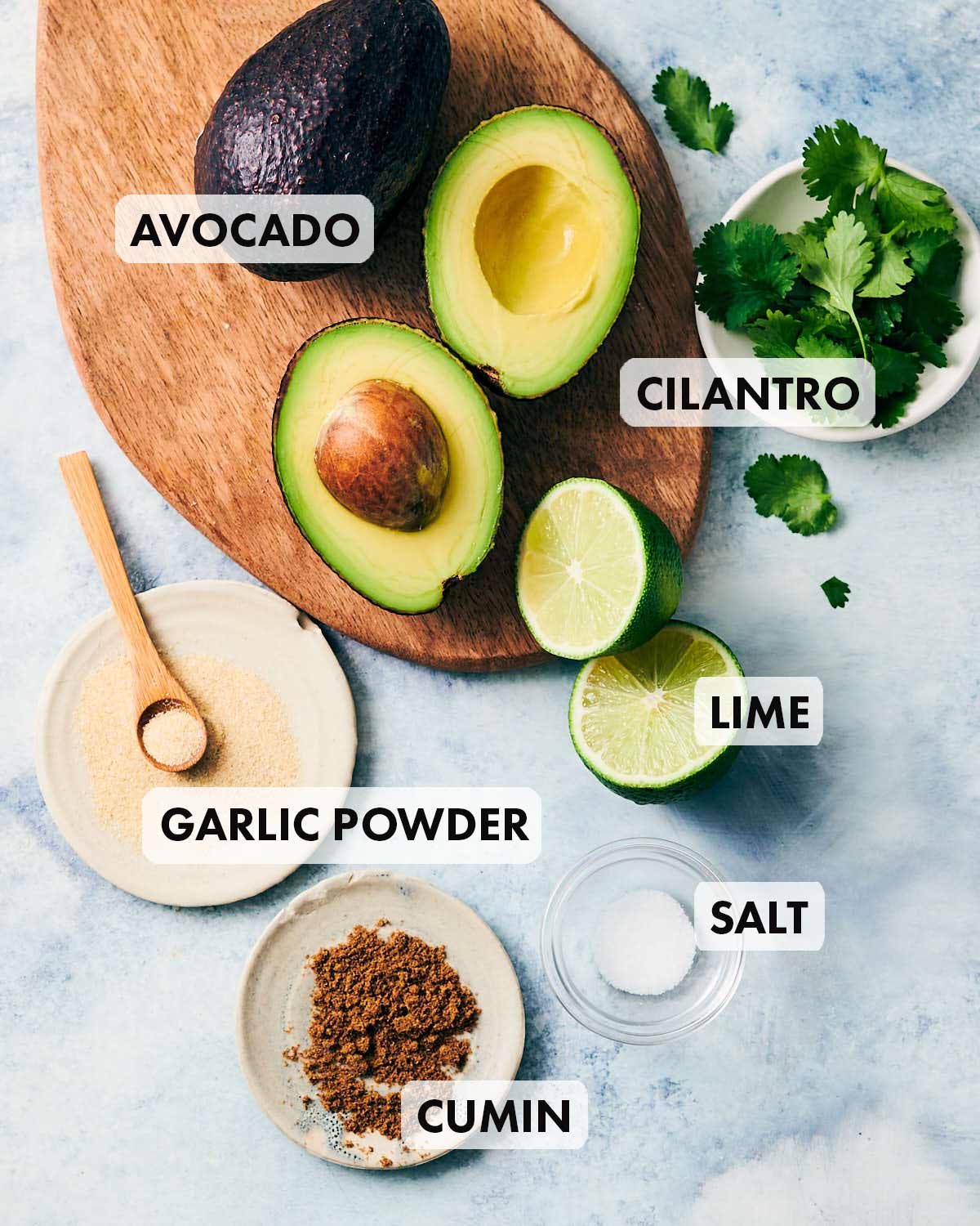 Ingredients to make vegan guacamole without tomatoes.