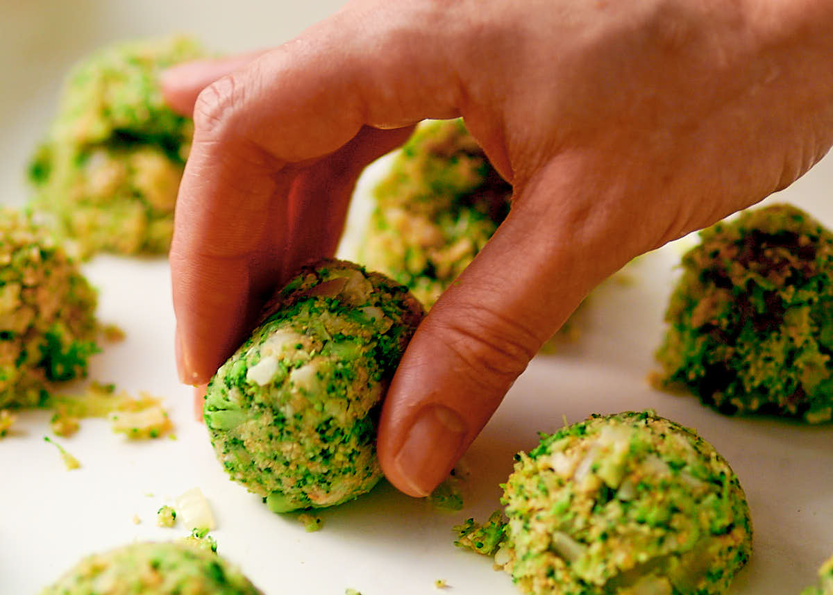 Hand shaping broccoli tater tots before they're baked in an air fryer.