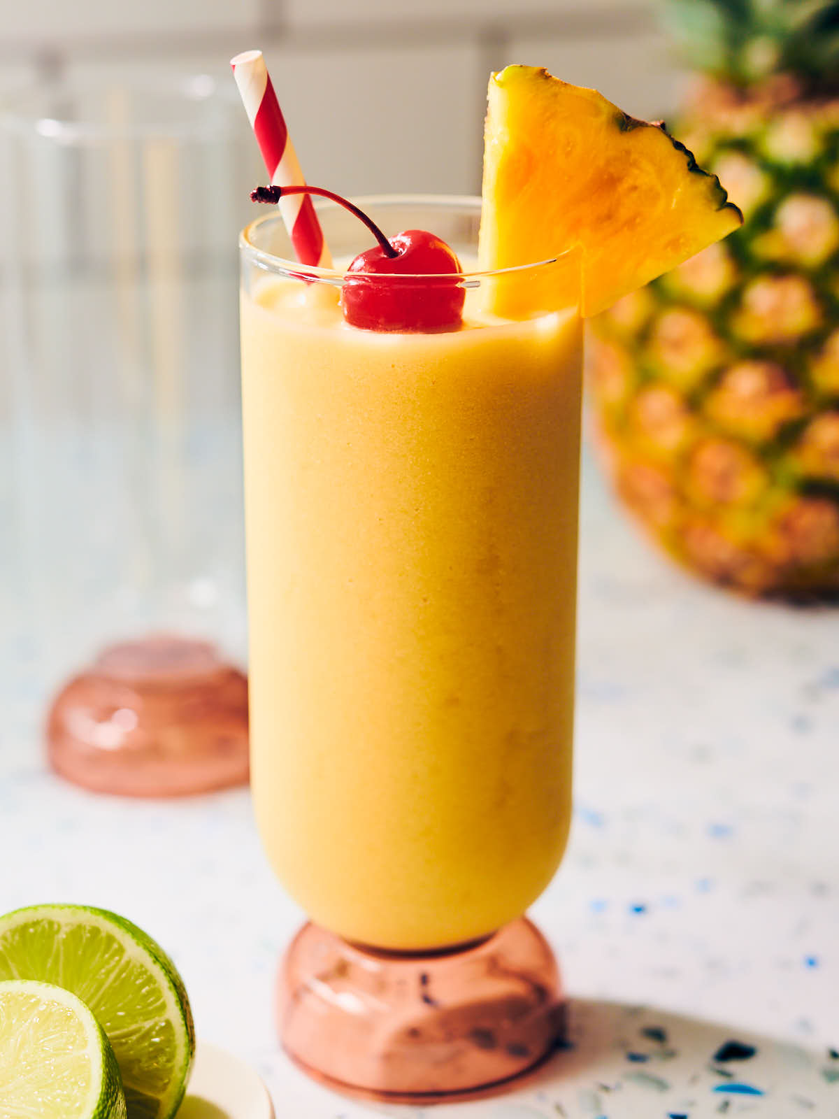 Virgin pina colada mocktail in a tall glass topped with pineapple.