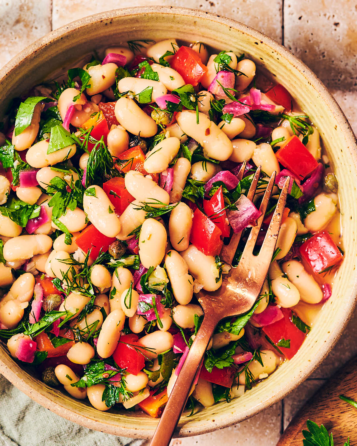 A bowl of easy Cannellini Bean Salad with a fork.