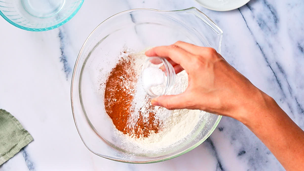 Mixing dry ingredients in a glass bowl for muffins.