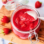 Strawberry Rhubarb Compote in a glass jar with a spoon.