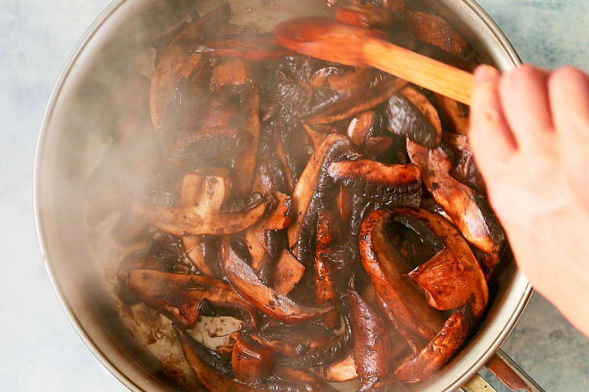 Sauteeing portobello mushrooms in a skillet.