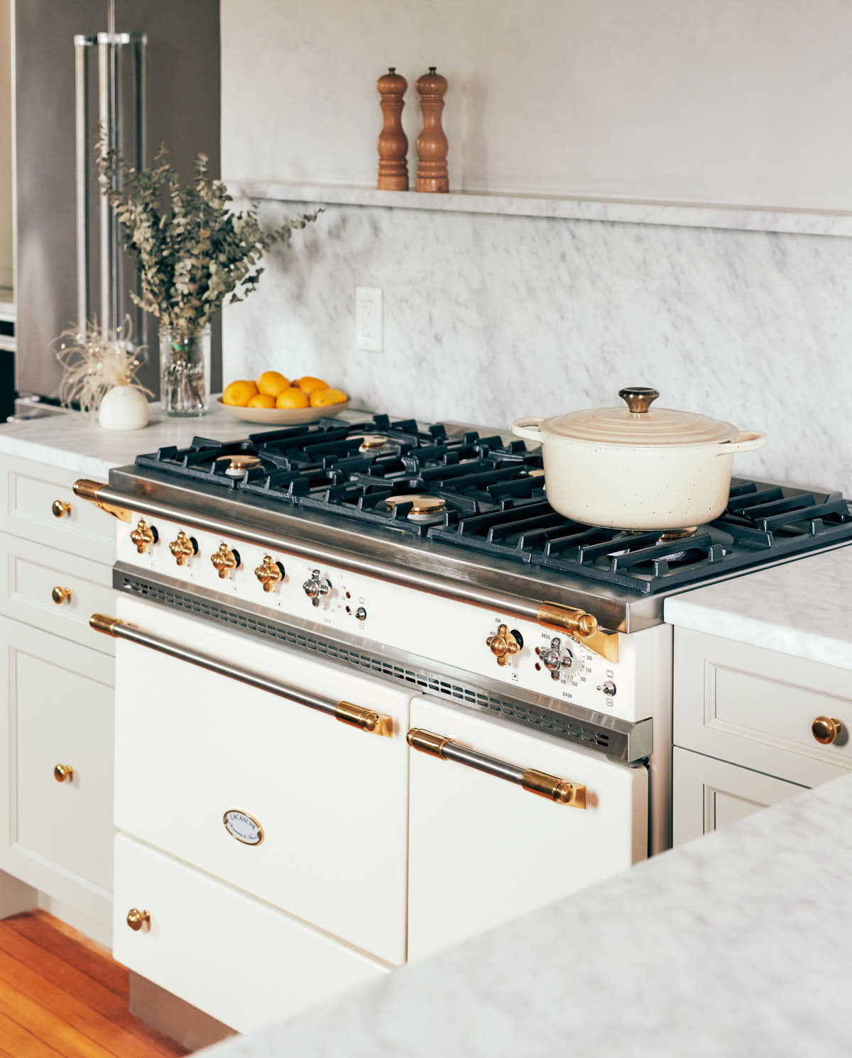 White Lacanche stove in a kitchen with marble counters.