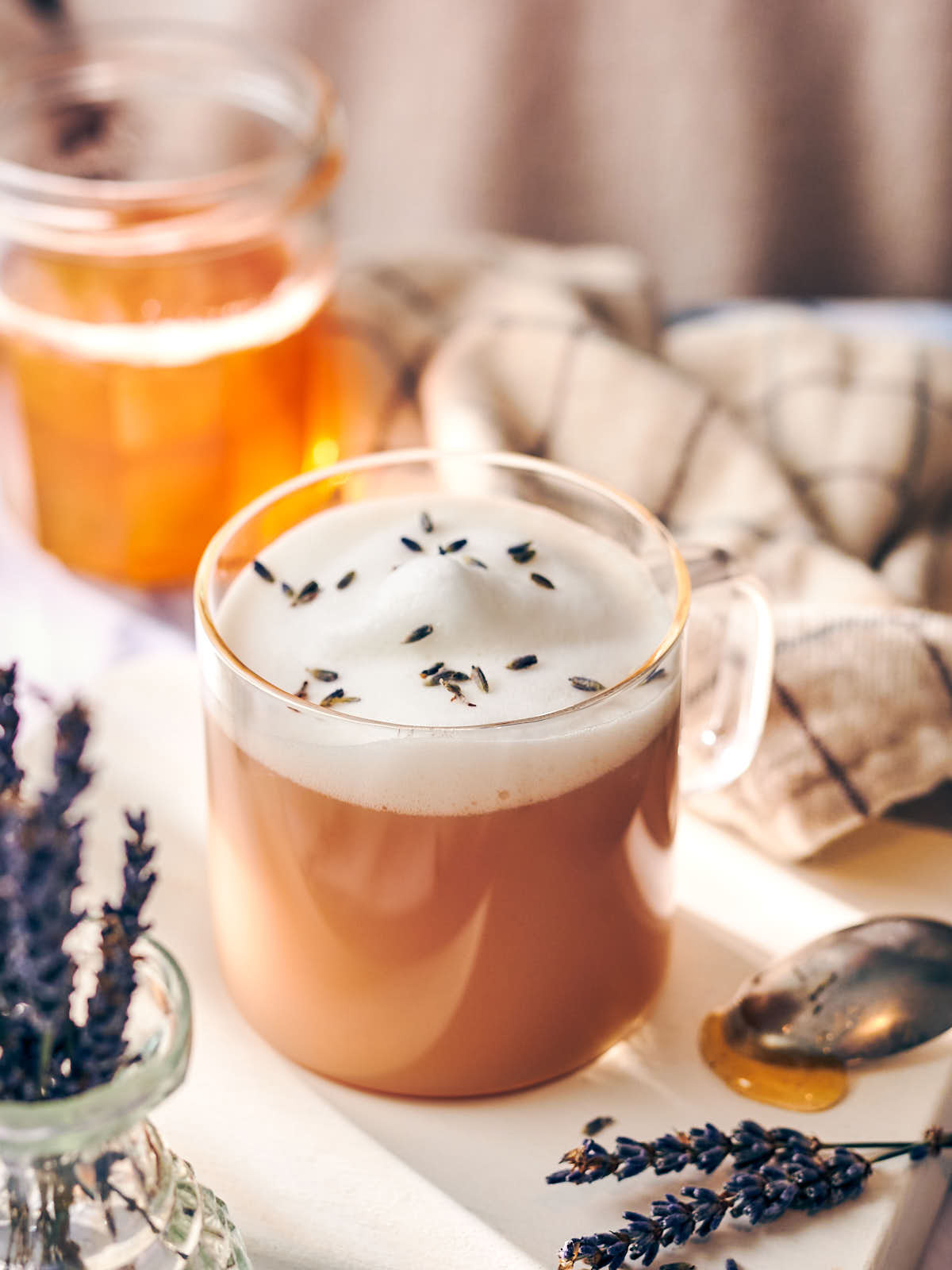 Earl grey tea latte sweetened with lavender honey in a glass mug.