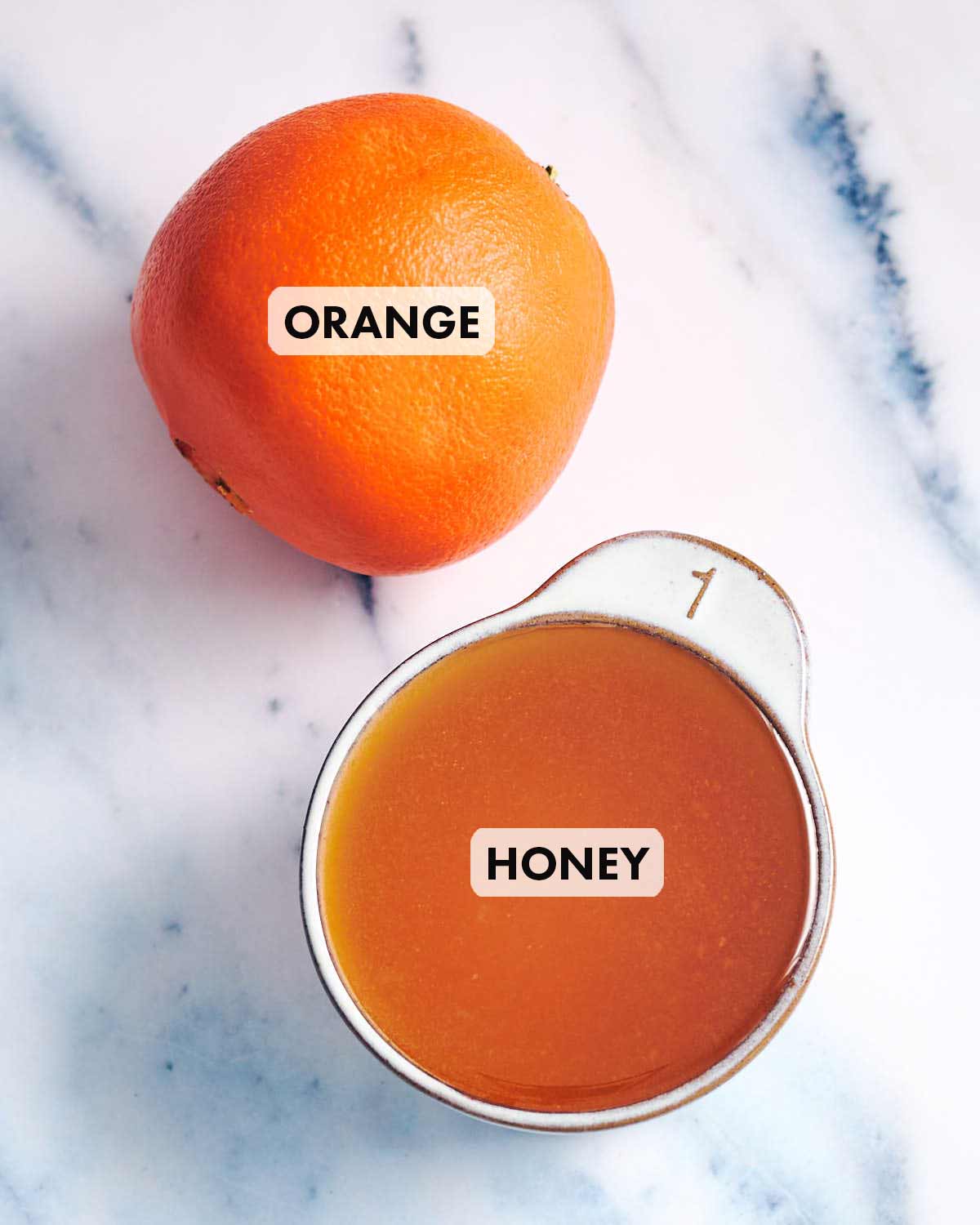 Ingredients to make orange honey, including a fresh orange.