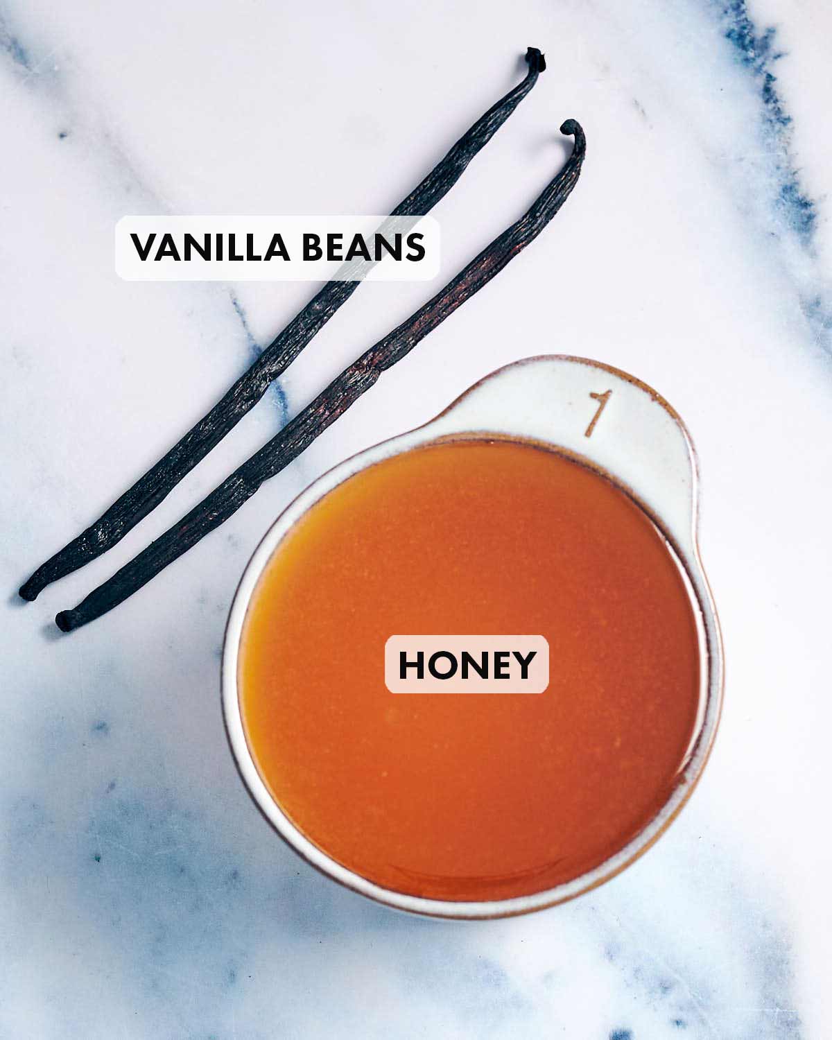 Ingredients to make infused vanilla honey (vanilla beans and honey).