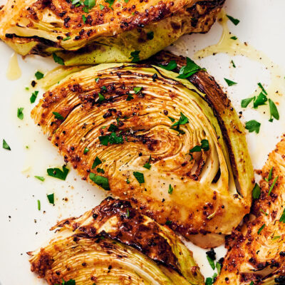 Air fryer cabbage wedges on a white serving plate.