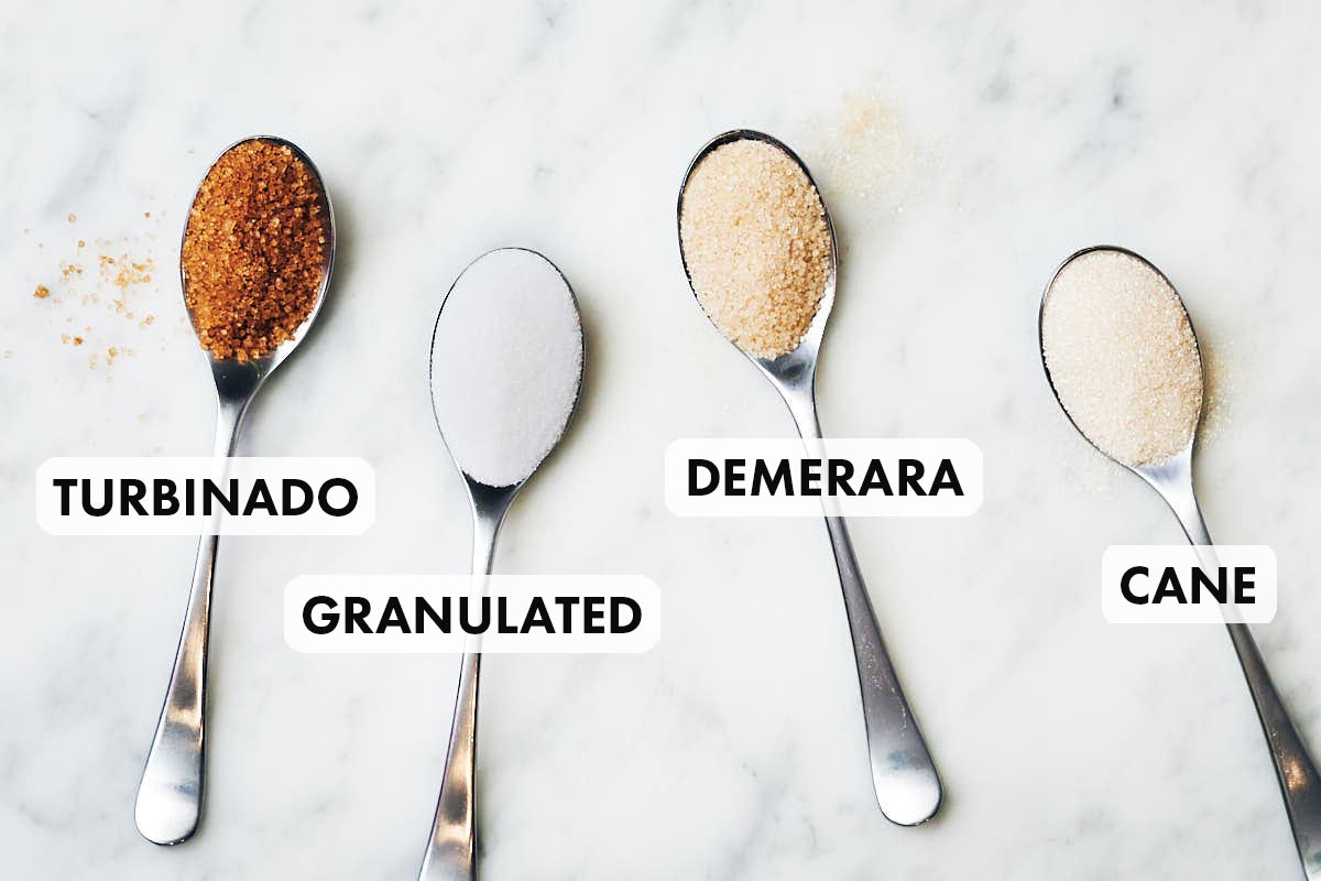 4 types of sugar on spoons: Turbnado, Granulated, Demerara, Cane sugar.