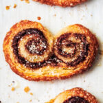 Chocolate Nutella puff pastry palmiers on parchment paper.