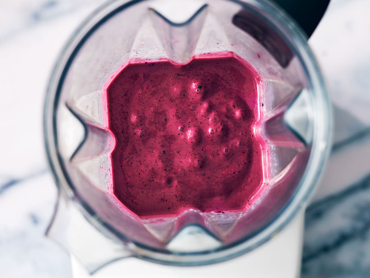Blueberry raspberry smoothie in a blender container, after blending.