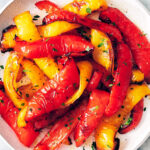 Air fryer peppers topped with parsley on a plate.