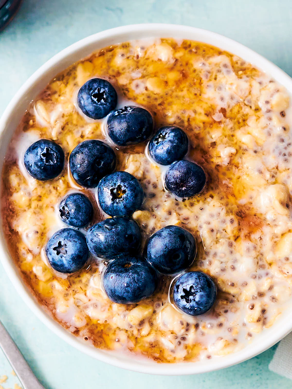 Homemade maple syrup alternative on a bowl of overnight oats with blueberries.