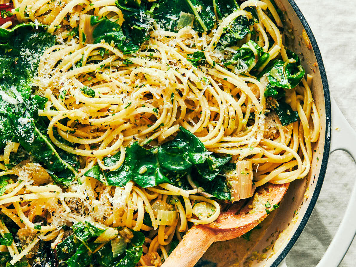 Lemon Swiss Chard pasta in a skillet with a serving spoon.