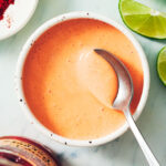Roasted Red Pepper Crema in a bowl with a spoon.
