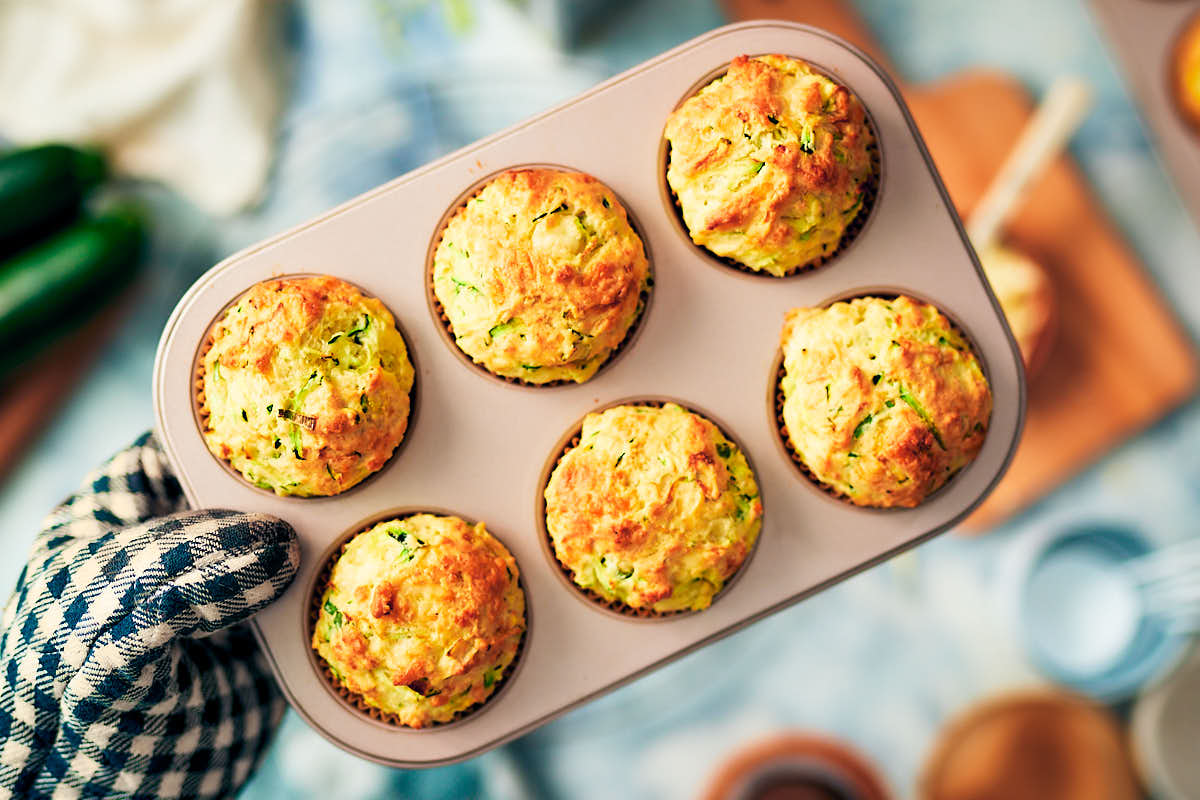 One bowl savory zucchini muffins in a muffin tin after baking.