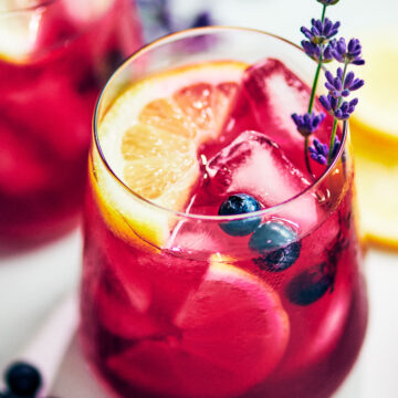 Easy Blueberry Lavender Lemonade in a glass with lemon.