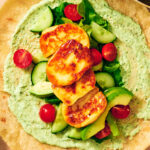 Seared halloumi, creamy cilantro sauce, and fresh veggies on a wrap.