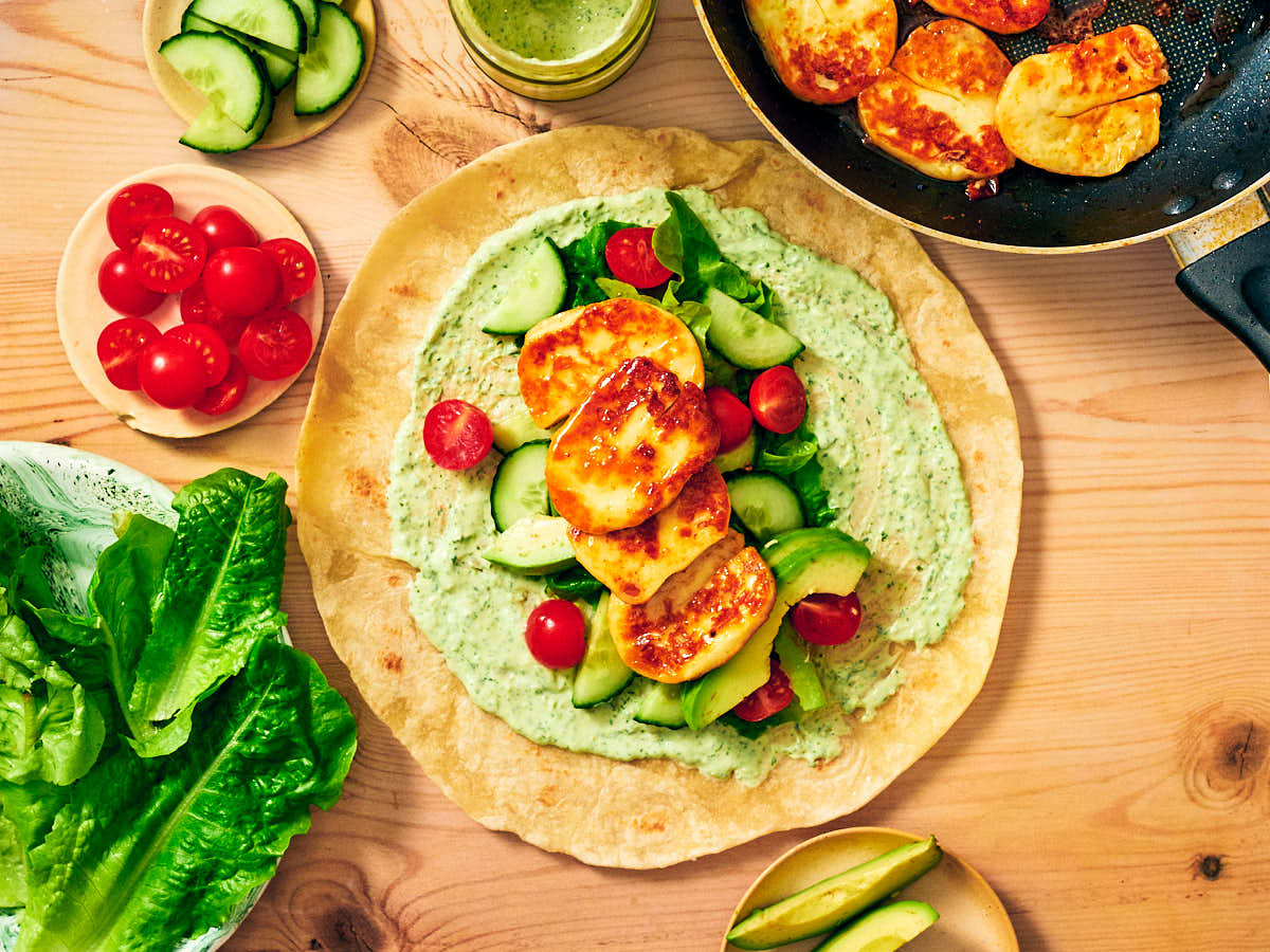 Halloumi Wraps with Hot Honey on a wooden table with ingredients.