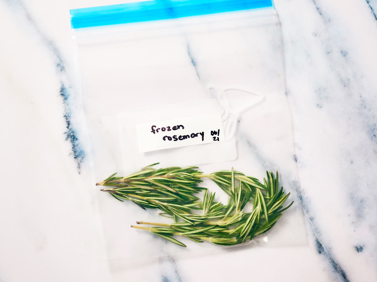 Frozen rosemary sprigs in a freezer bag.