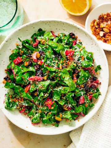 Easy Swiss Chard Salad in a bowl on a table with water glass and napkin.