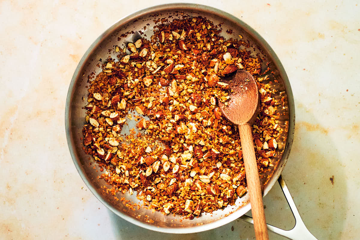 Toasted panko breadcrumbs, garlic, and almonds in a skillet.