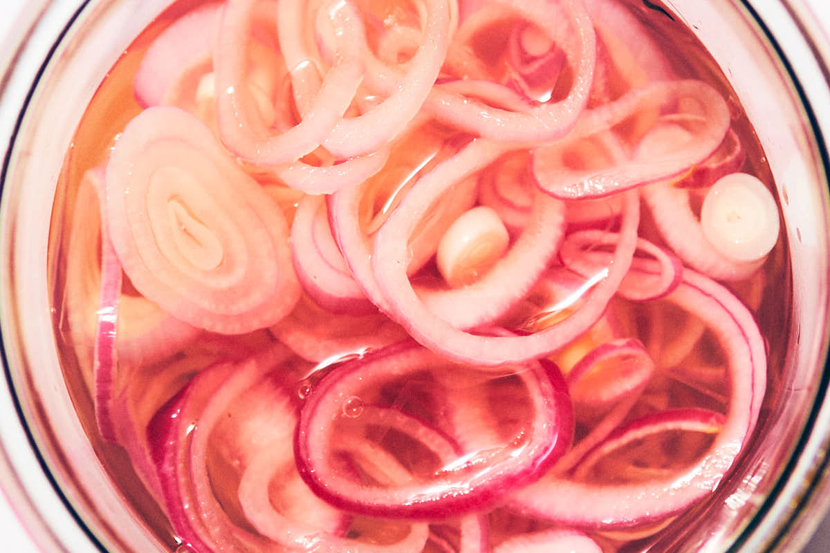 Quick pickled shallots in a jar, ready to eat.