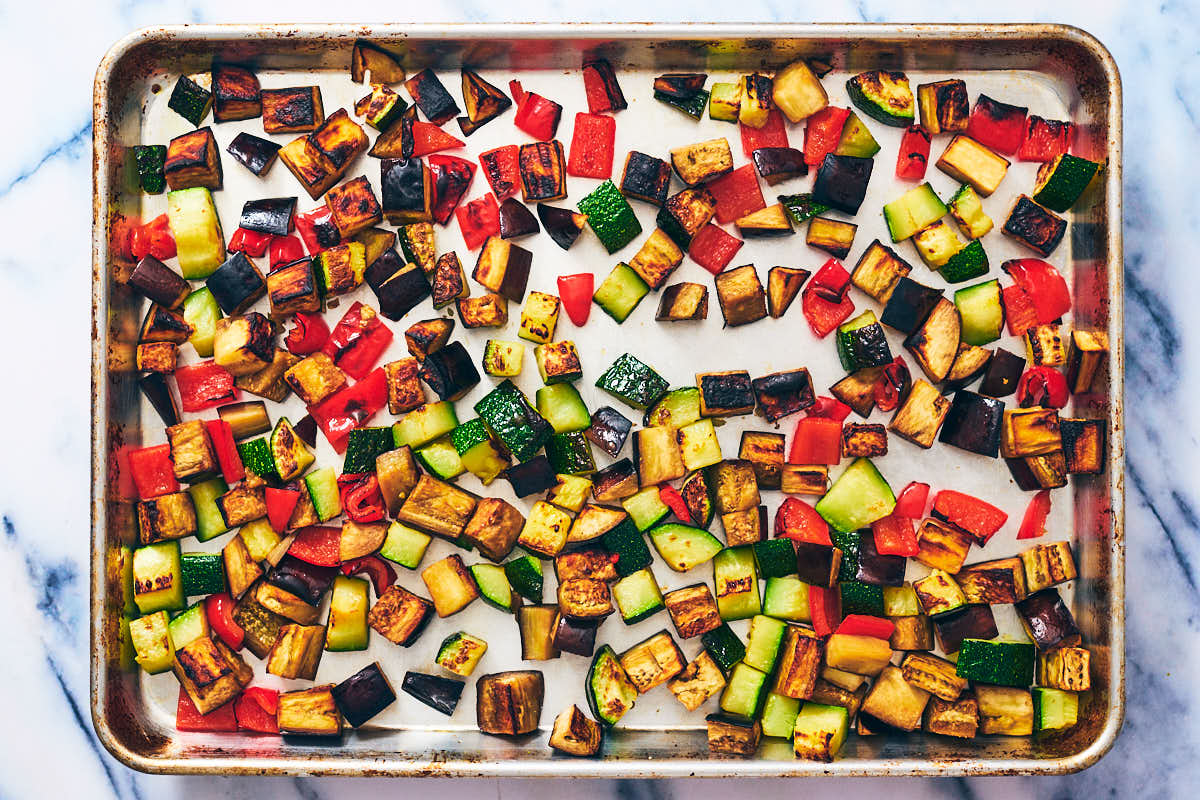 Roasted vegetables on a baking sheet for ratatouille recipe.