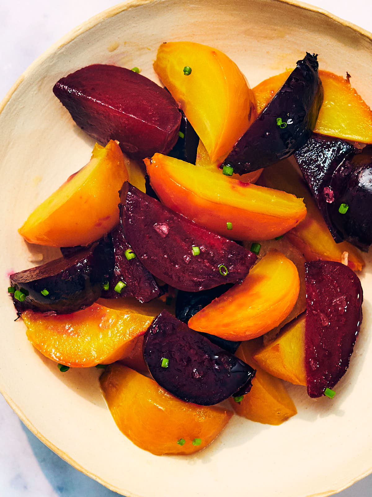 Red and Golden Air Fryer Beets in a bowl with chives.