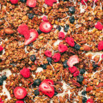 Best Homemade Berry Granola with oats and coconut on a baking sheet.
