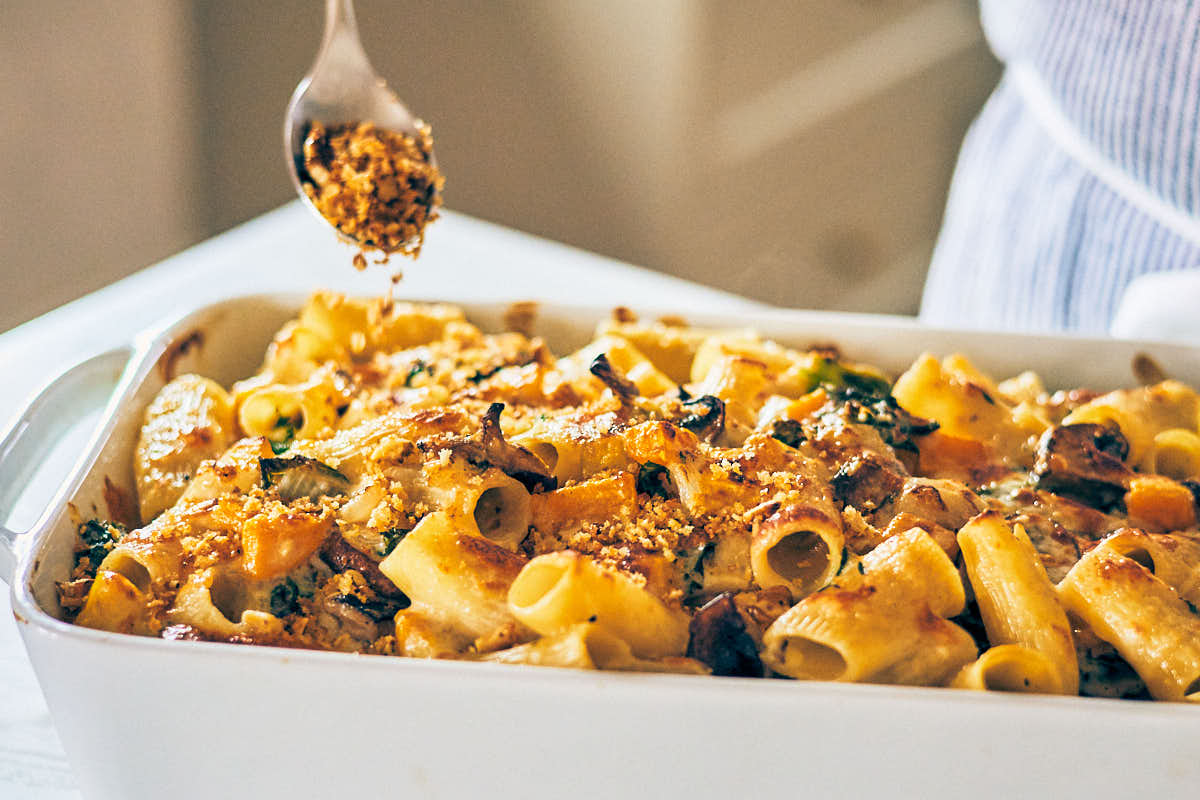 Sprinkling panko breadcrumbs over Cheesy Butternut Squash Pasta Bake.