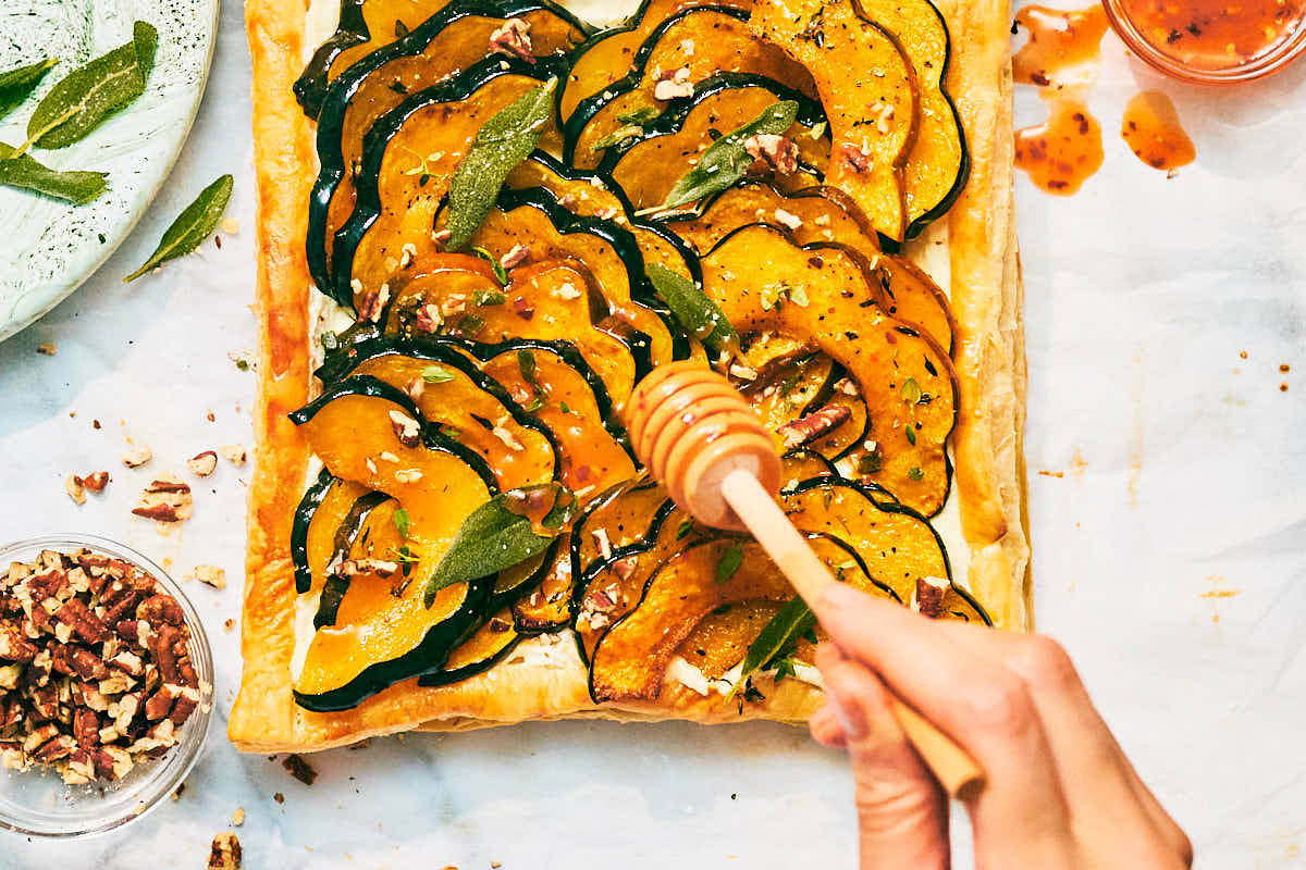 Roasted Squash Tart being drizzled with hot honey.