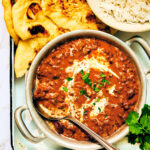Easy Instant Pot Dal Makhani in a bowl with naan and rice on the side.