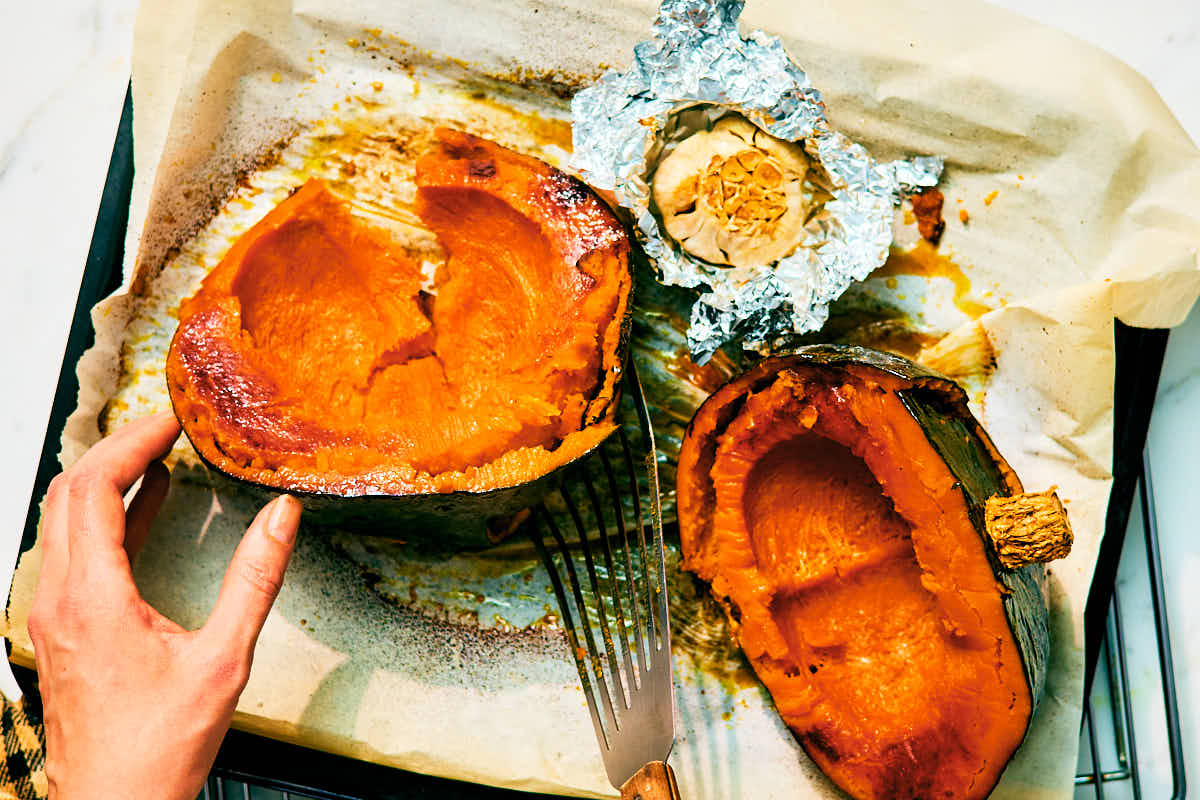 Roasted kabocha squash and garlic cooling on a baking sheet.