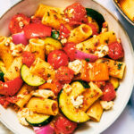 Red Chimichurri Pasta with zucchini, tomatoes, and feta on a plate.