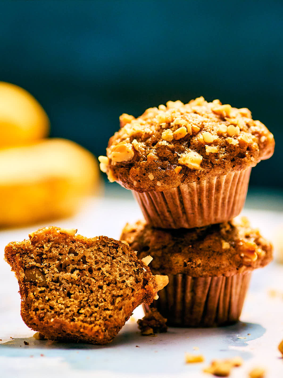 A stack of mini Banana Nut Bread Mini Muffins topped with walnuts.