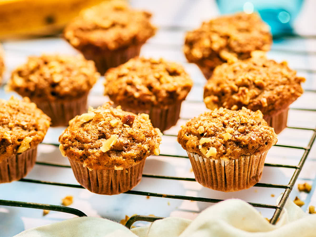 Banana Nut Bread Mini Muffins with walnuts on a cooling rack.